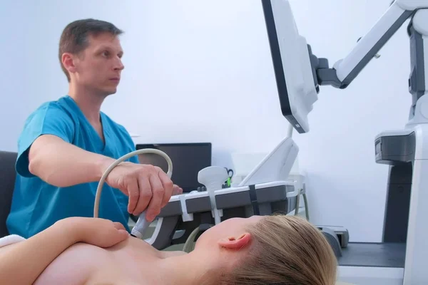 Hombre médico haciendo ultrasonido diagnóstico de las glándulas mamarias de la mujer joven . — Foto de Stock