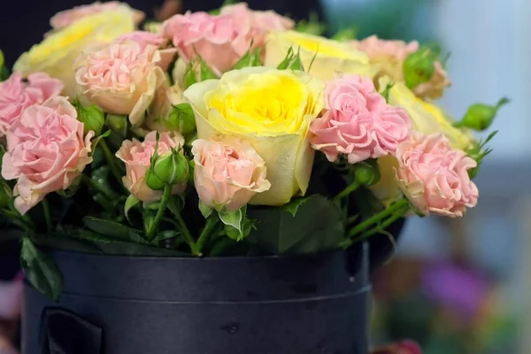 Florista mujer girando ramo de rosas en la mesa en la tienda de flores, vista de cerca . — Foto de Stock