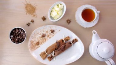 Çikolata Rusça krep blini plaka üzerinde doldurma lor ile. Bir fincan çay ve çikolata ile servis. Üstten Görünüm.