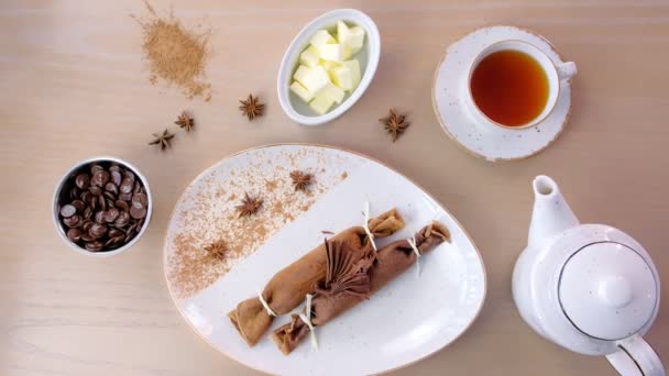 Шоколад Російська млинців, млинці з сиром начинкою на тарілку. Подається з чашкою чаю і шоколаду. Вид зверху. — стокове відео