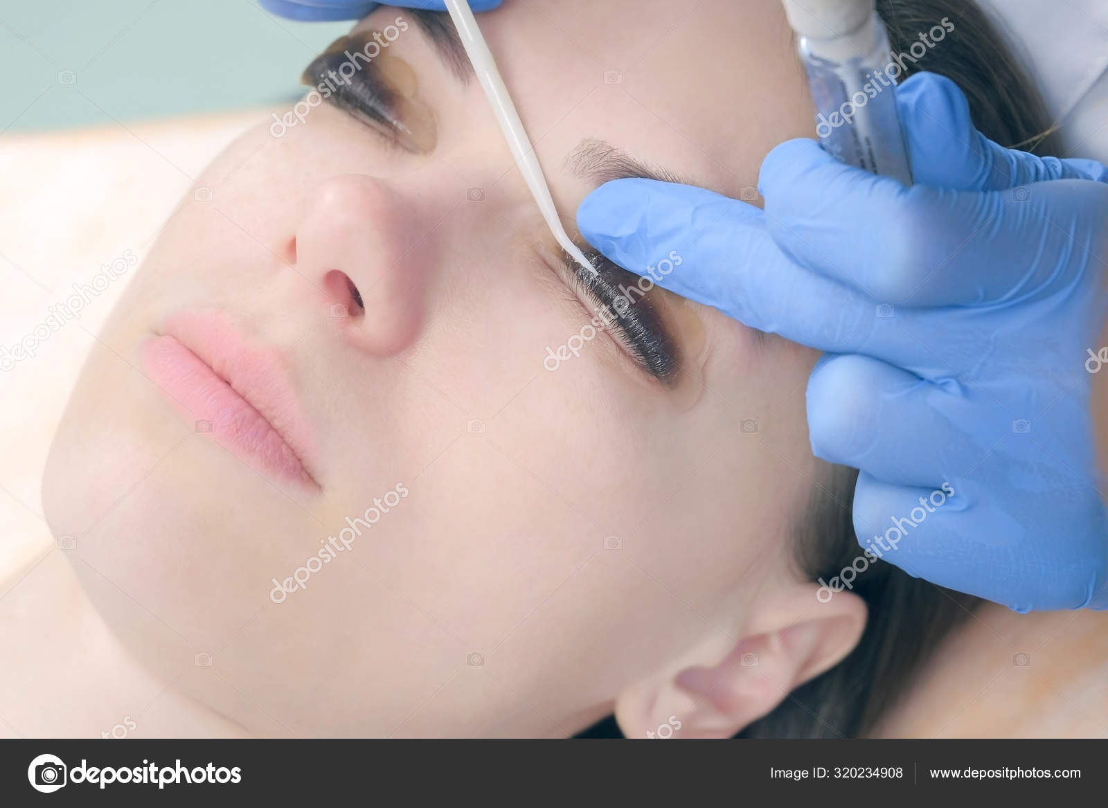 Beautician bending lashes with needle into curlers, lift eyelashes