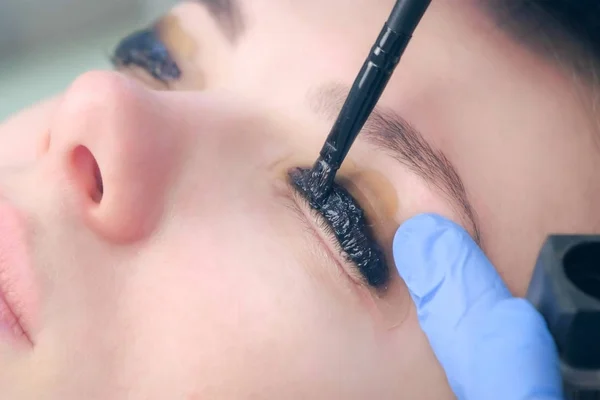 Kozmetik uzmanı kirpiklere boya sürüyor, kirpikleri kaldırıyor..