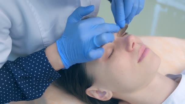 Výtah laminace řasy procedura v kosmetické klinice k mladé ženě, tvář detailní up. — Stock video