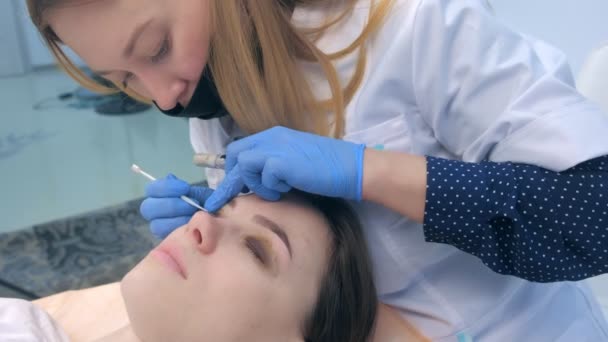 Cosmetologue flexion des cils avec aiguille dans les bigoudis, soulever les cils stratifié. — Video