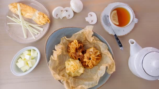 Julienne zapiekane w cieście podawane na talerzu na papierze baker z herbata i masło. — Wideo stockowe