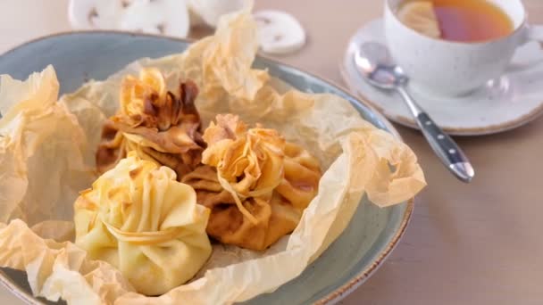 Julienne gebakken in deeg geserveerd op een plaat op baker papier met thee en boter. Close-up weergave. — Stockvideo