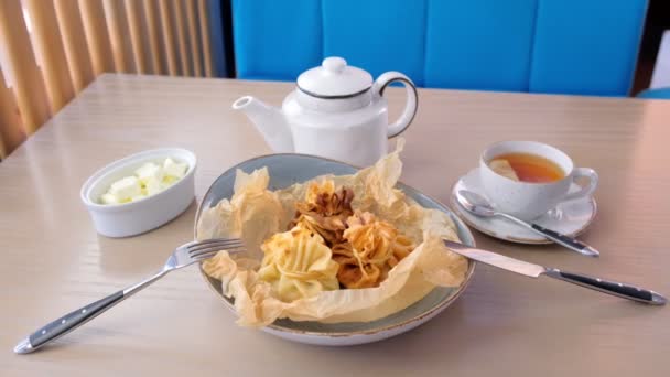 Julienne gebacken in Teig auf einem Teller auf Backpapier mit Tee und Butter serviert. Ansicht von oben. — Stockvideo