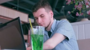 Güdük elleri ile engelli adam dizüstü bilgisayar ve görüşmeler cep telefonu kafede çalışıyor.
