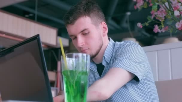 Behinderter Mann mit Stummelhänden arbeitet im Café am Laptop und telefoniert mit Handy. — Stockvideo