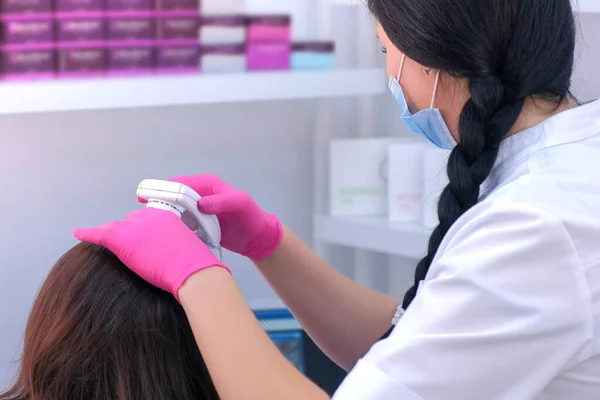 Trichologist examina cabelos de paciente mulher usando tricoscopia de computador na clínica . — Fotografia de Stock