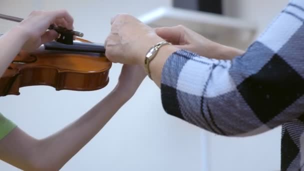 Professor de música ensina criança a tocar violino na escola musical, mãos fechadas . — Vídeo de Stock