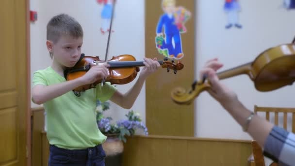 Kind jongen student viool speelt met leraar in muziek les op muzikale school. — Stockvideo