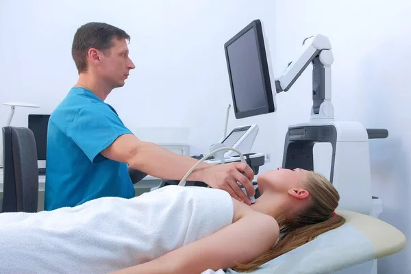 Doctor makes ultrasound scanning diagnostic of thyroid gland to woman in clinic. — Stock Photo, Image