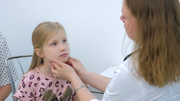 Gyermekorvos nő szondázás nyirokcsomók nyakán lány gyermek vizsgálat során. — Stock videók