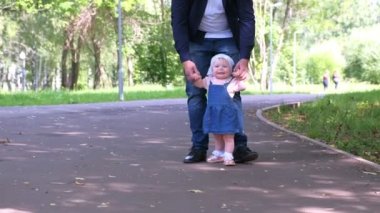 Bebek şehir parkında babasının elini tutarak ilk adımı atmaya çalışıyor..
