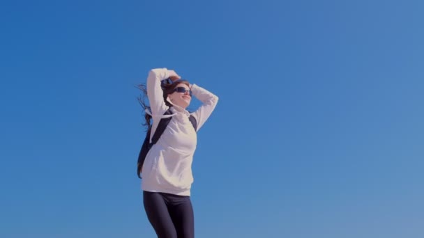 Felice vincitore ragazza salta in posa vittoria con alzando le mani sfondo cielo blu . — Video Stock