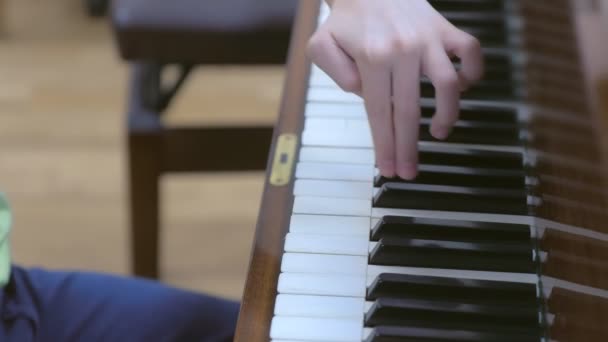 学校の音楽教室でピアノを練習している少年. — ストック動画