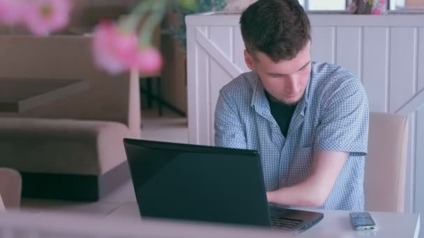 Behinderter Mann mit Stummelhänden arbeitet im Café am Laptop und telefoniert mit Handy. — Stockvideo