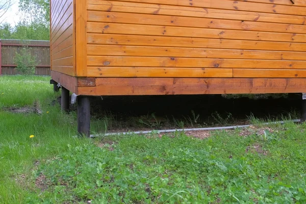 Trä hus på styltor på gård gård gård, styltor närbild. — Stockfoto