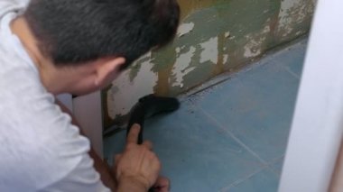 Man vacuuming construction garbage after repairing works in lavatory room.