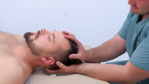 リハビリテーション療法のクリニックで患者の首を押すカイロプラクター. — ストック動画