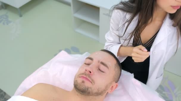 Cosmetologo sta pulendo schiuma detergente da uomo pazienti faccia in clinica di bellezza . — Video Stock