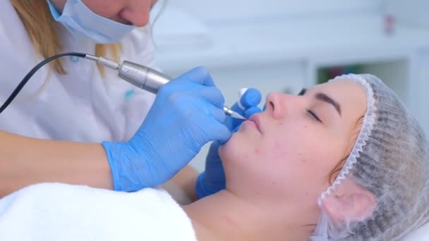 Beautician εφαρμογή μόνιμη μακιγιάζ στα χείλη κάνει περίγραμμα χρησιμοποιώντας μηχανή τατουάζ. — Αρχείο Βίντεο