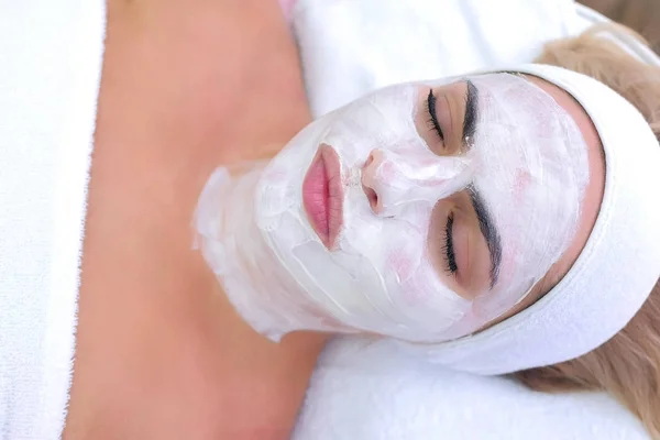 Portrait of woman lay in spa salon with white mask on face, top view . — Stok Foto