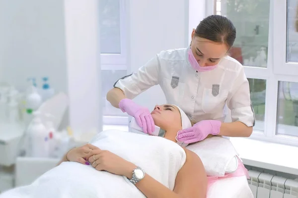 Cosmetólogo haciendo procedimiento de limpieza facial ultrasónica a la mujer en la clínica . —  Fotos de Stock