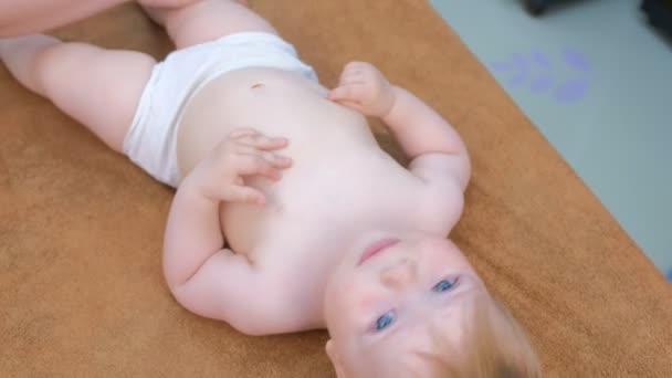 Πορτρέτο του χαμογελαστού μωρού που κάνει προληπτικό μασάζ στην κλινική από το γιατρό. — Αρχείο Βίντεο