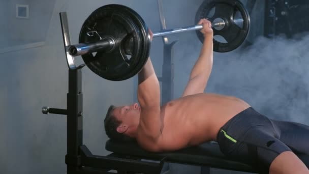 Profissional musculoso atlético homem fisiculturista fazendo exercício de barbell no banco . — Vídeo de Stock
