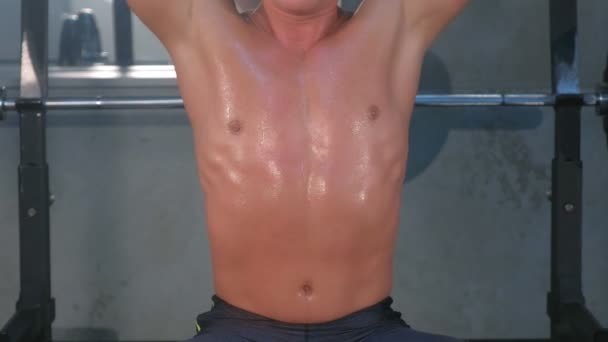 Musculoso joven haciendo hombros sobre la cabeza levantamiento de prensa con pesas en el gimnasio . — Vídeos de Stock