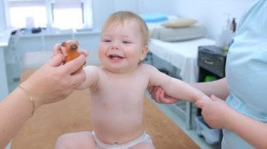 Doktor tarafından klinikte koruyucu masaj yapan gülümseyen bebeğin portresi..