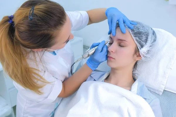 Cosmetologist fazendo sobrancelhas microblading procedimento no salão de beleza para menina. — Fotografia de Stock