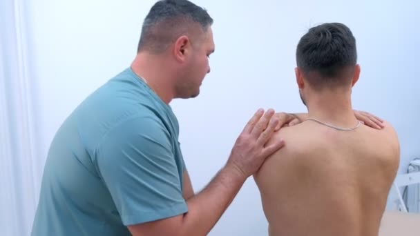 Doctor chiropractor behandelt patiënt schouder in kliniek op revalidatietherapie. — Stockvideo
