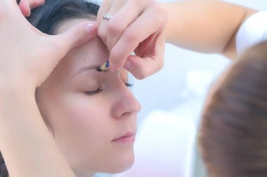 Güzellik uzmanı, mikroplu patinaj işleminden önce müşterileri için kaş boyuyor.