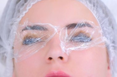 Güzellik uzmanı kadın kirpiklerini, pedlerini, havlularını, kirpiklerini kaldırıyor..