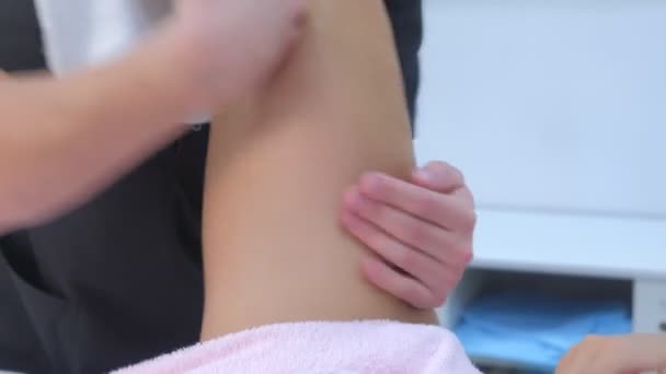 Mann Arzt macht skulpturale Körperheben Massage für Frau reiben Bein in Klinik. — Stockvideo