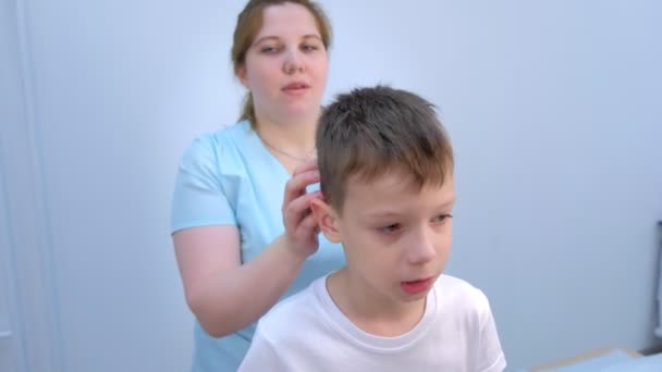 Médecin professionnel masseur fait thérapie tête massage pour adolescent garçon dans clinique . — Video