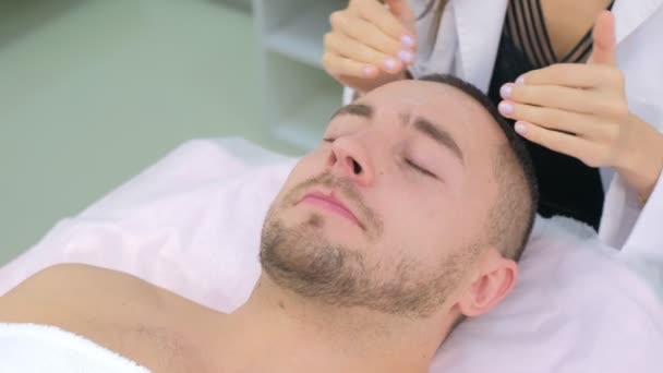 Femme cosmétologue applique la lotion mousseuse sur le visage patient mans pour nettoyer . — Video