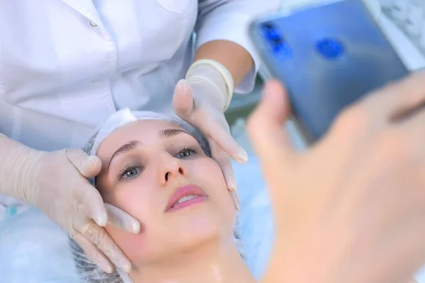 Donna blogger stava facendo massaggio facciale riprese video sul telefono cellulare, primo piano . — Foto Stock