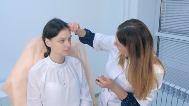 Cosmetologo pittura a forma di matita delle sopracciglia donna prima della procedura di colorazione . — Video Stock