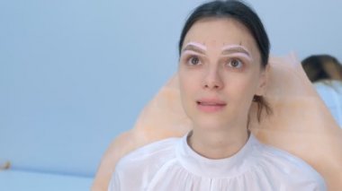 Portrait of woman with painted shape of eyebrows on face before tinting.