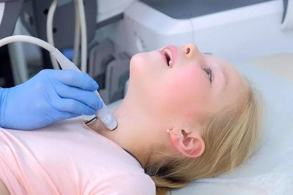 Doctor examining child girl thyroid gland using ultrasound scanner, closeup. — Stock Photo, Image