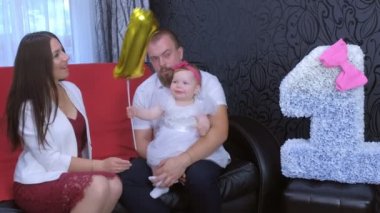 İlk doğum günü partisinde anne, baba ve bebeğin aile portresi..