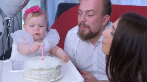 Bayi perempuan menyentuh lilin di atas kue akan terbakar dan menangis pada ulang tahun pertamanya . — Stok Video