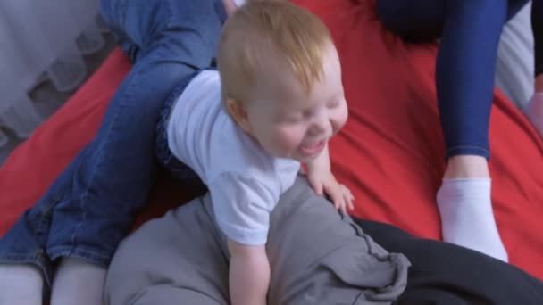Portrét usměvavého jednoletého miminka, jak se dívá na kameru, jak sedí v posteli. — Stock video