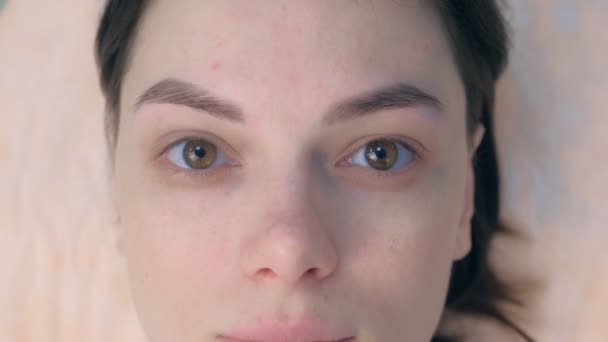 Портрет женщины после тонирования бровей, смотрящей в камеру в косметологической клинике . — стоковое видео