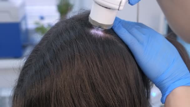 Lékař tricholog vyšetřuje ženy vlasy pomocí dermatoskopu na klinice. — Stock video