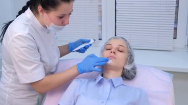 Kozmetik uzmanı biyo-evrimleşmeden önce cilde anestezik krem uyguluyor..